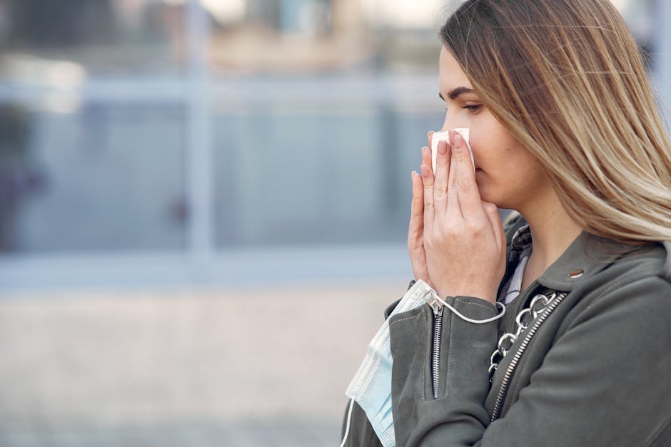 Woman sneezing outdoors into a tissue, experiencing spring allergy symptoms in nature.