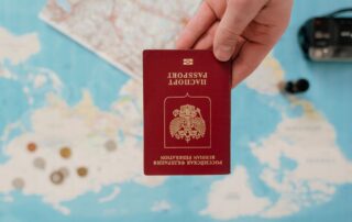 Open passport resting on a world map next to travel planning notes