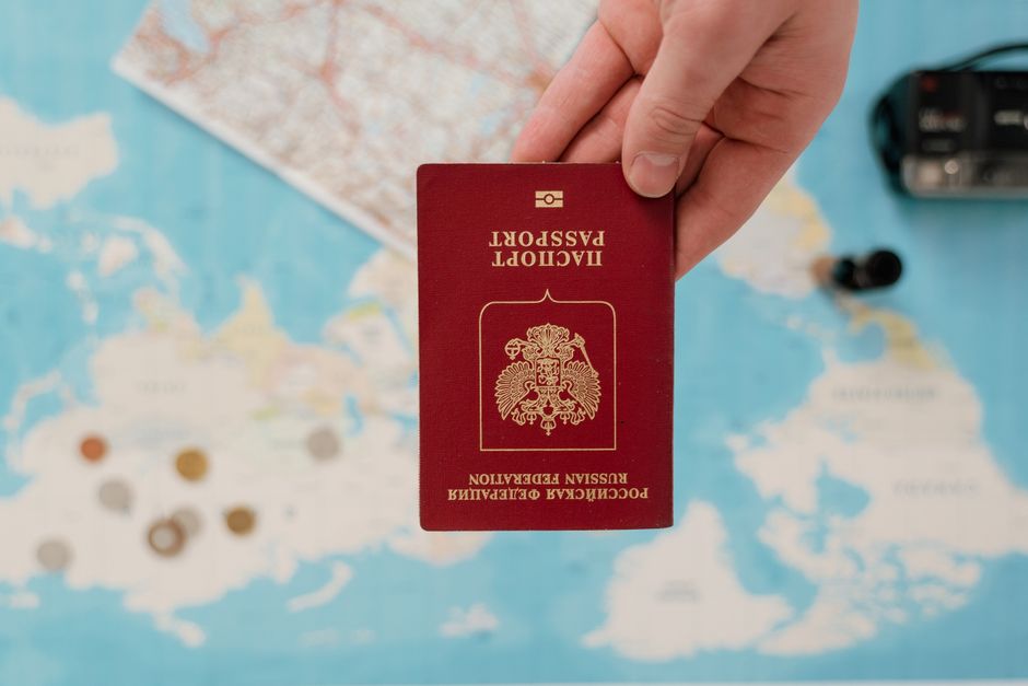Open passport resting on a world map next to travel planning notes